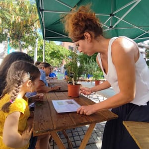Talleres Infantiles de Cosmética Natural y plantas medicinales en Barcelona 10 natalia de naturmentallers enseñando a una niña insectos de las plantas medicinales
