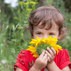 niña oliendo una flor medicinal en un taller infantil de naturmentallers