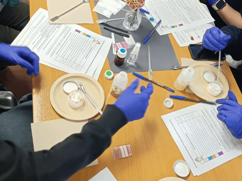 Grupo de taller de cosmética natural mostrando cremas hechas durante la clase