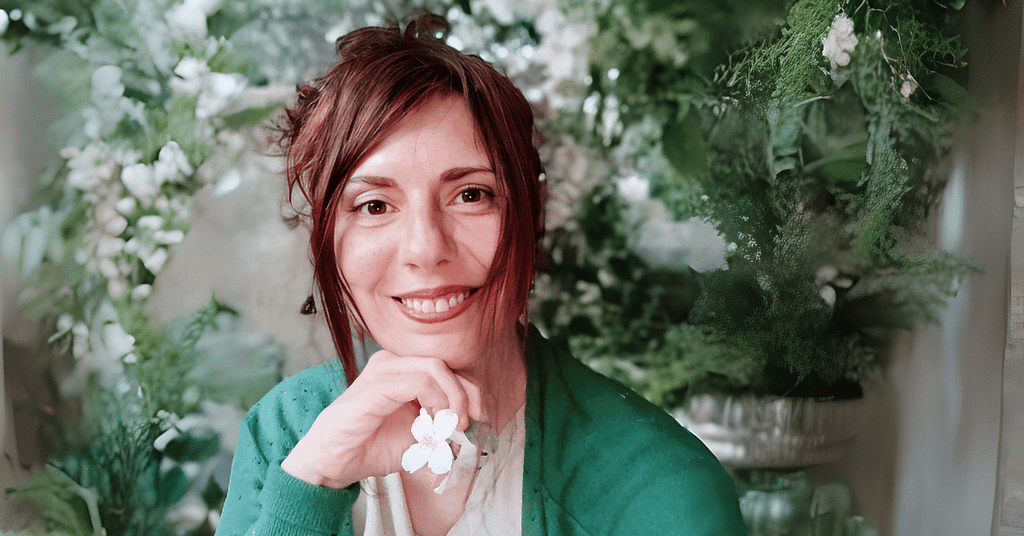 Natàlia, divulgadora de cosmética natural con plantas, rodeada de flores