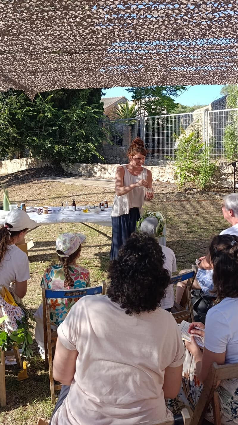 Natàlia impartiendo un taller de cosmética natural al aire libre para una entidad